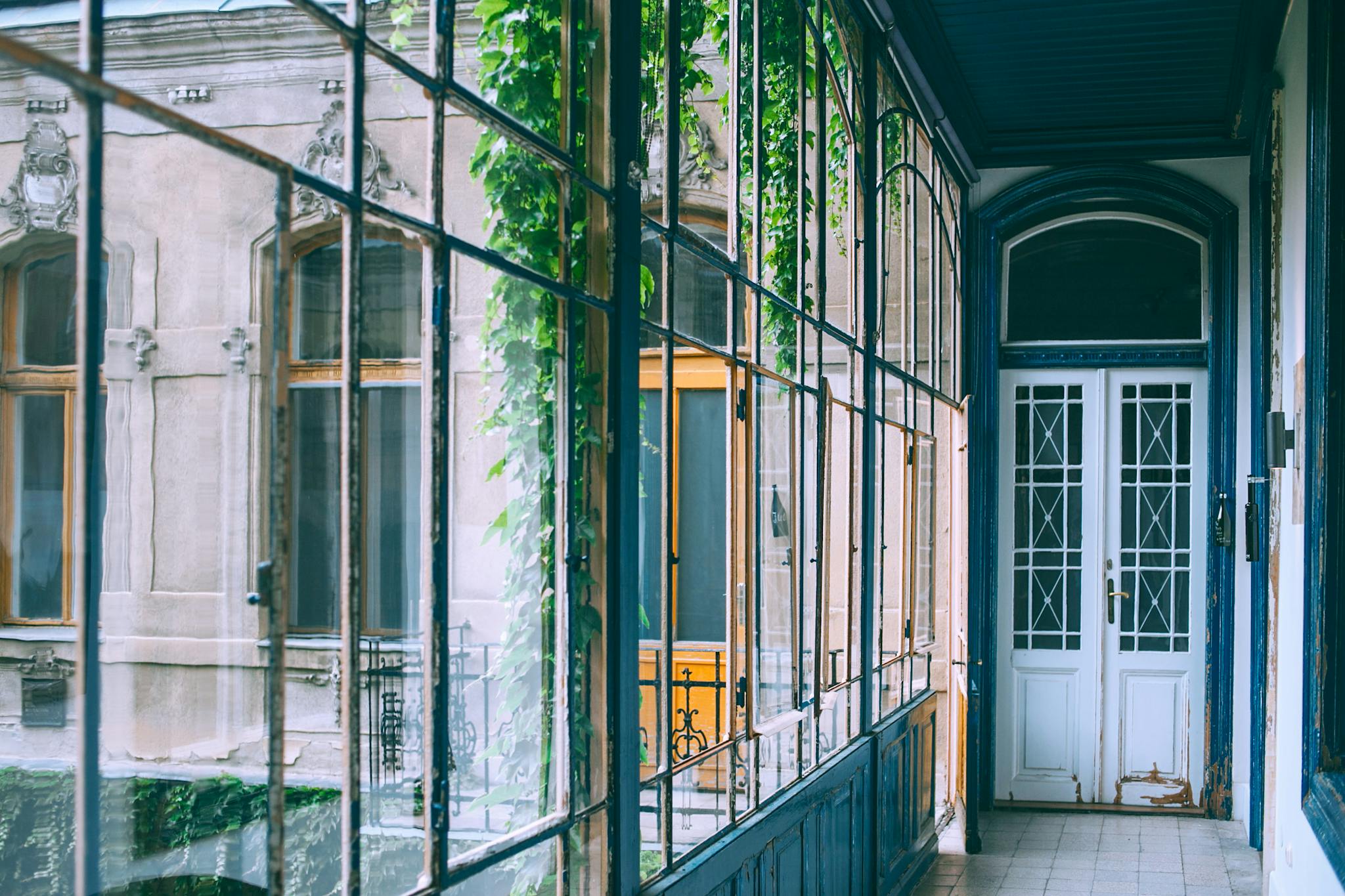 A classic corridor with glass walls reflecting a vintage architectural style.